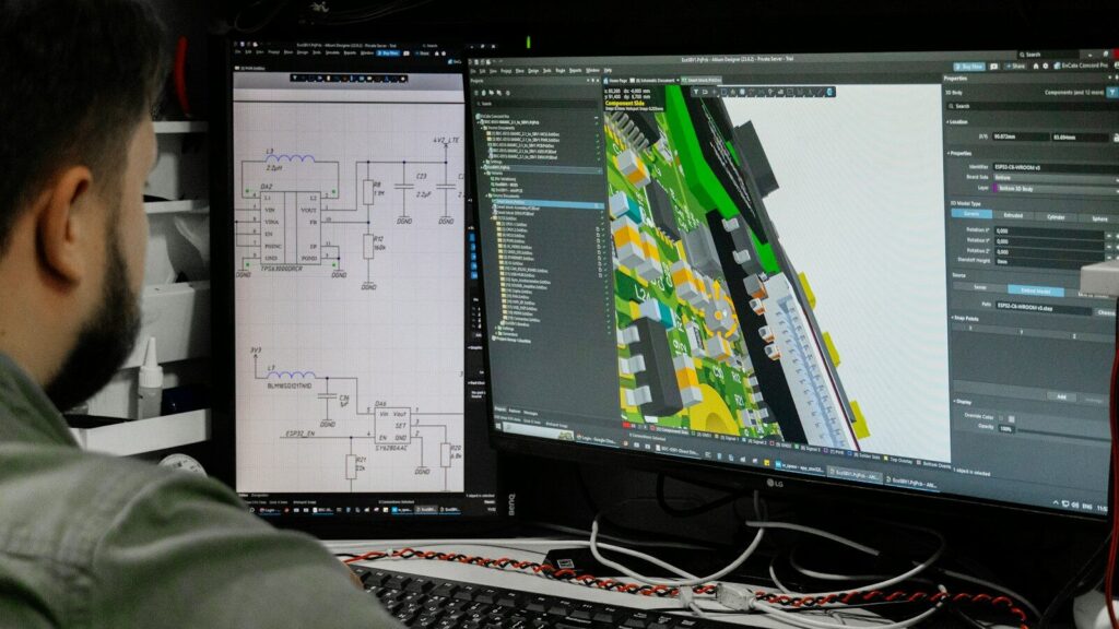 Man looking at circuit board design on computer screen